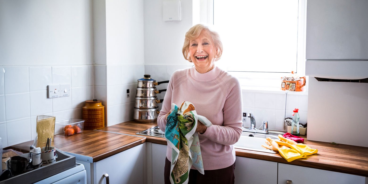 Retired woman drying dishes