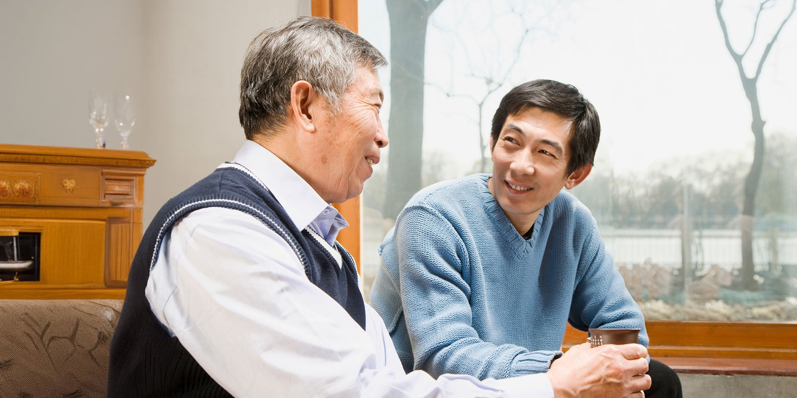 Son talking to older Dad at a table