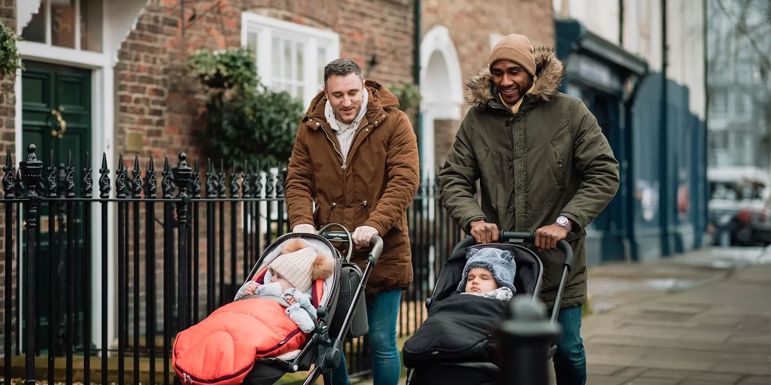 Two Dads walking with babies in strollers