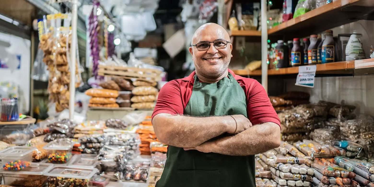 Small business owner proudly standing in front of products