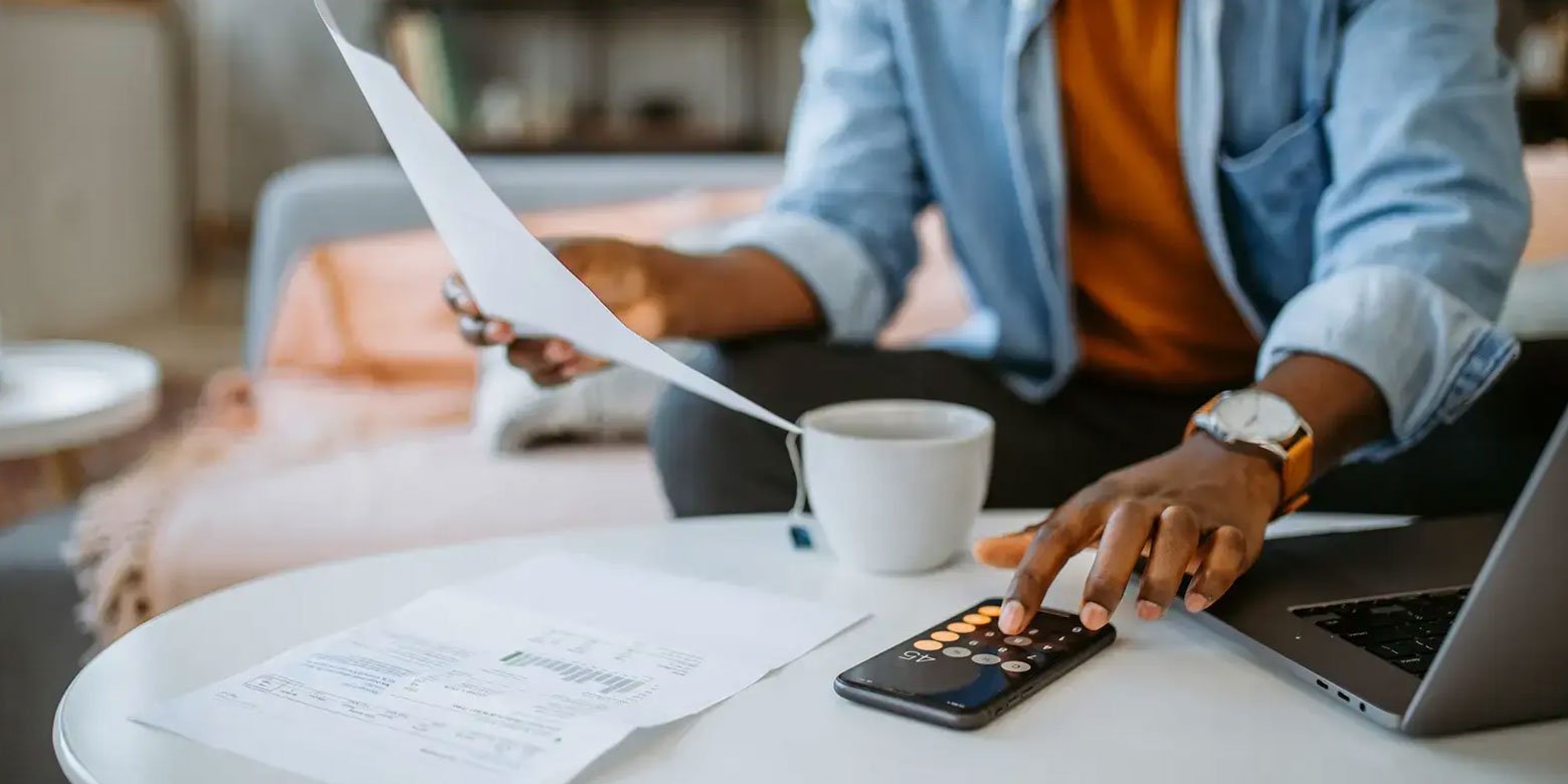 Man going through paperwork with a calculator