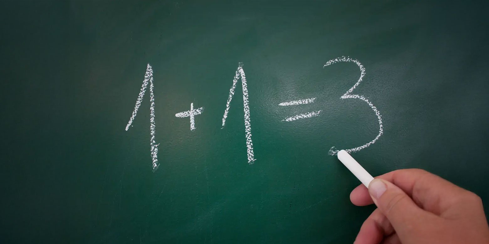 1 + 1 = 3 written on a chalk board