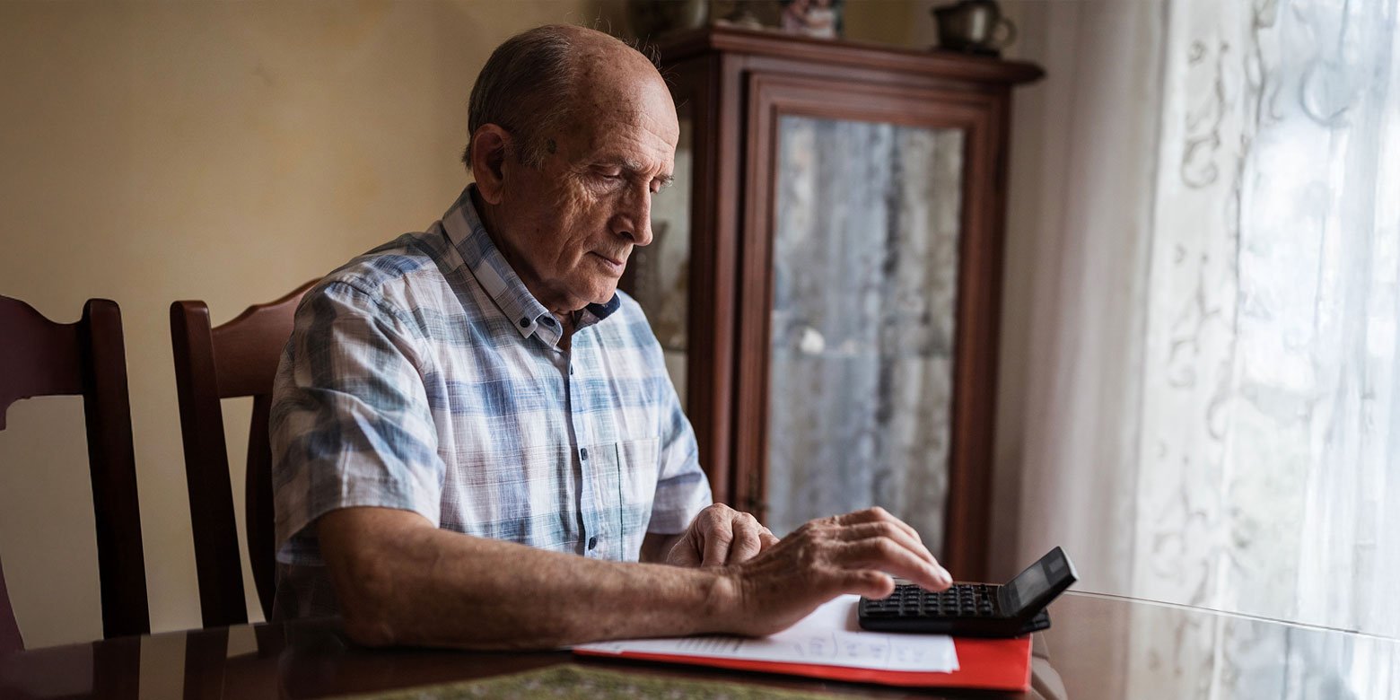 Elderly man with a calculator