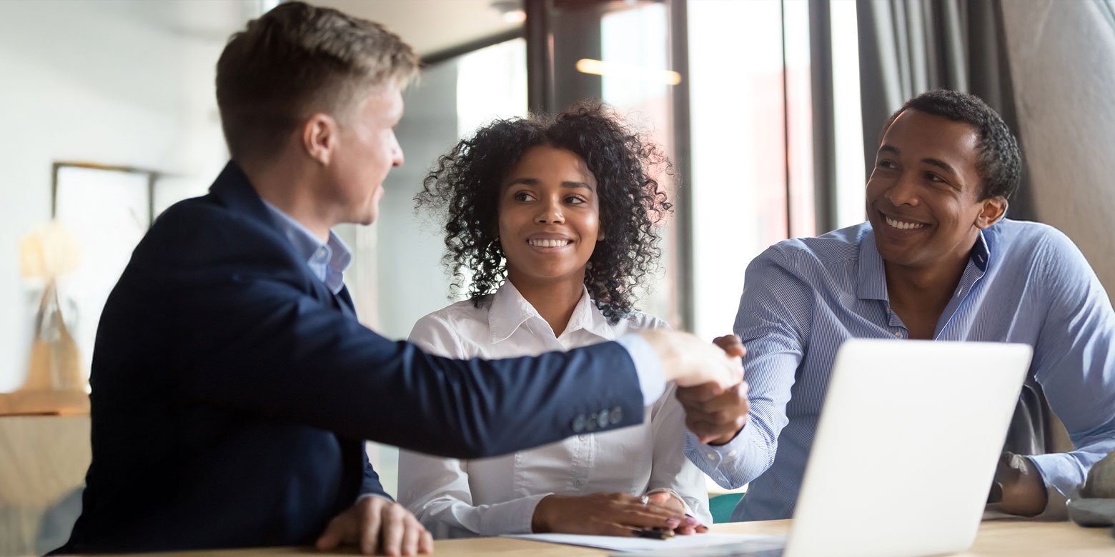 Advisor shaking hands with middle aged couple