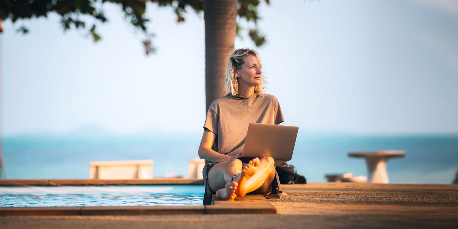Woman sitting on dock with a laptop