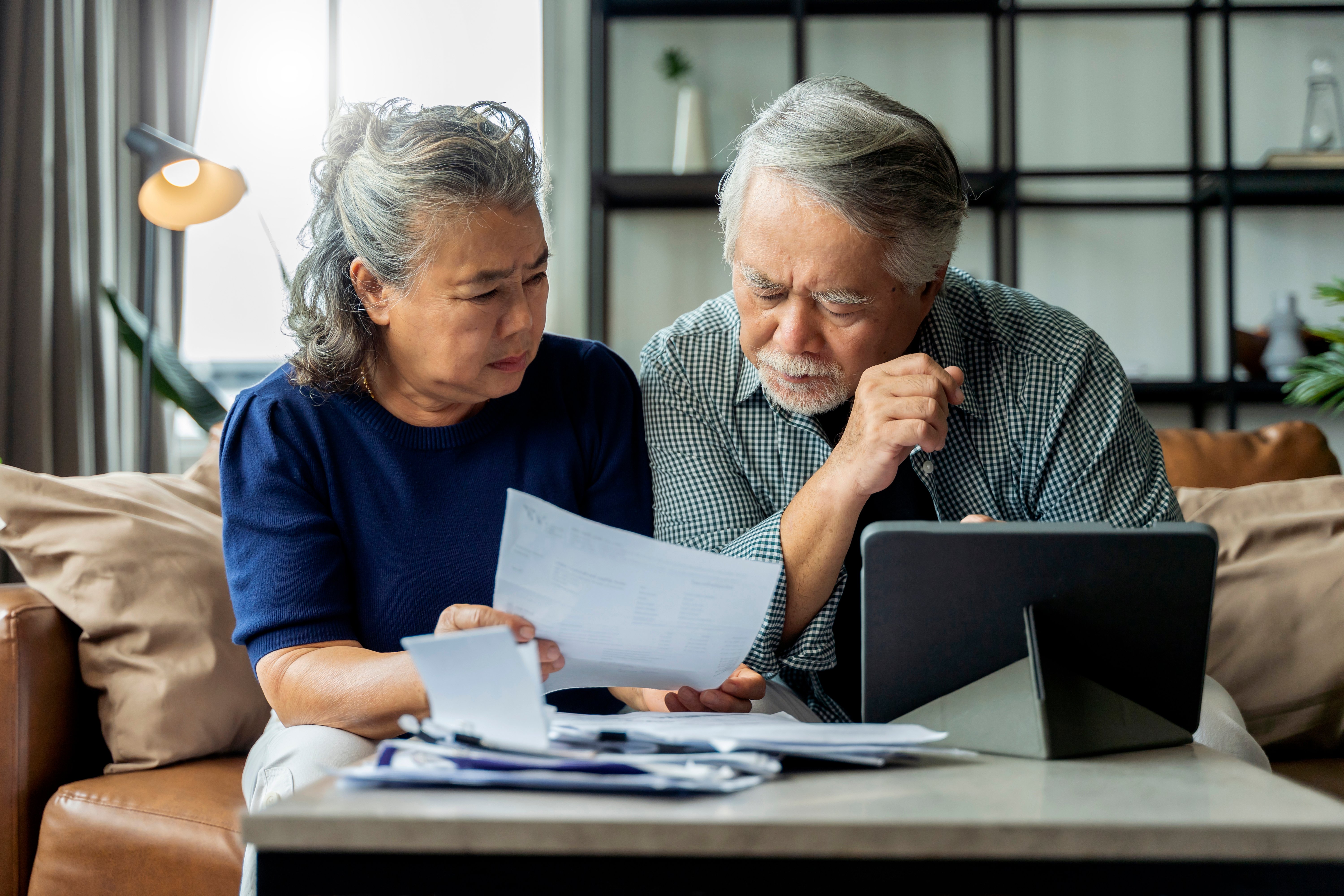 Retired couple review paperwork somberly